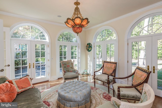 sunroom / solarium with a chandelier, a healthy amount of sunlight, and french doors