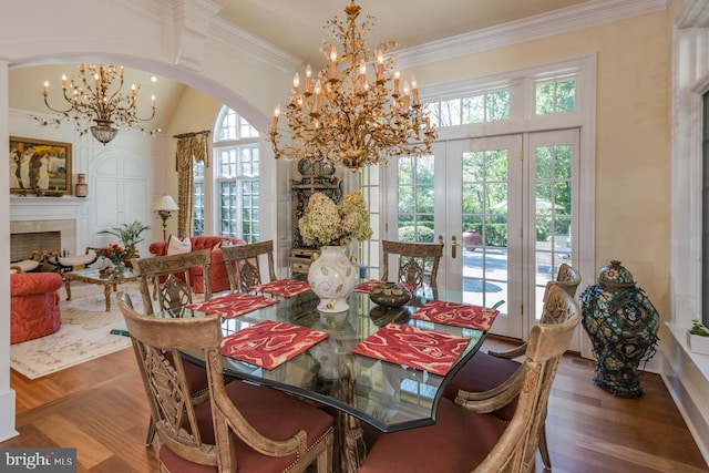 dining space featuring a notable chandelier, crown molding, dark wood-type flooring, and french doors