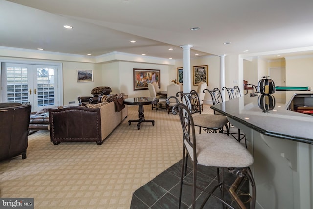 dining room featuring decorative columns, light colored carpet, ornamental molding, and french doors