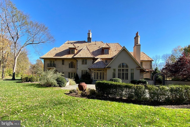 back of house with a lawn