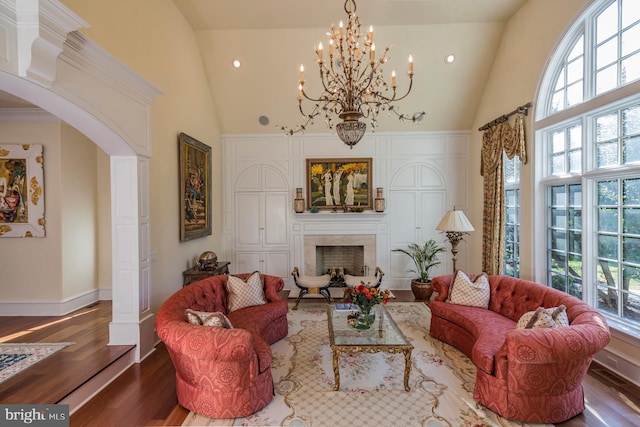 living room featuring a chandelier, decorative columns, high vaulted ceiling, and dark hardwood / wood-style floors