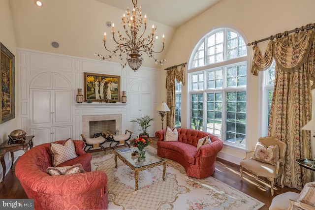 living room with a wealth of natural light, dark wood-type flooring, and a chandelier