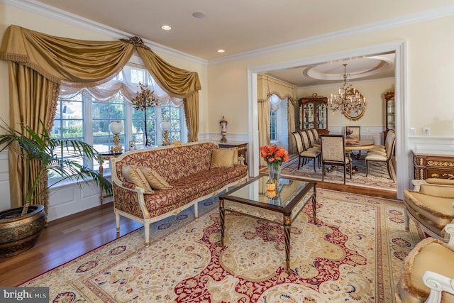 sitting room with an inviting chandelier, crown molding, and wood-type flooring