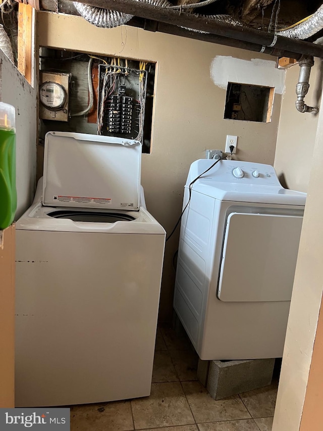 washroom with washing machine and dryer and light tile floors