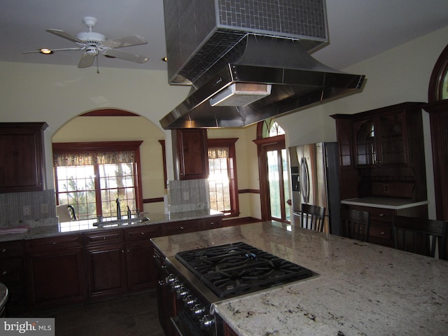 kitchen with tasteful backsplash, stainless steel fridge, ceiling fan, island range hood, and stove