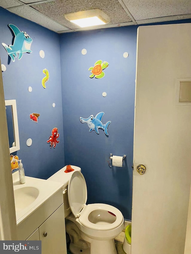 bathroom with toilet, large vanity, and a paneled ceiling