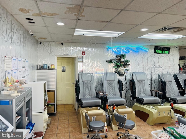 miscellaneous room with light tile flooring and a paneled ceiling