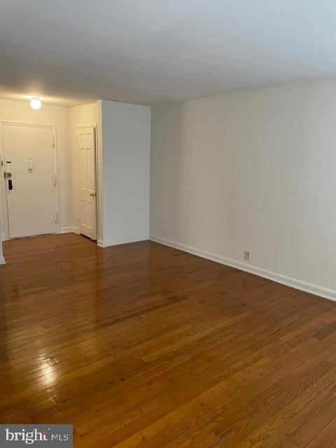 unfurnished room with dark hardwood / wood-style flooring