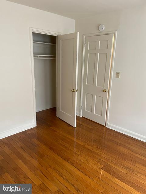 unfurnished bedroom with a closet and dark hardwood / wood-style floors