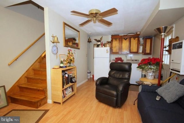 living room with washer / clothes dryer, ceiling fan, and light wood-type flooring