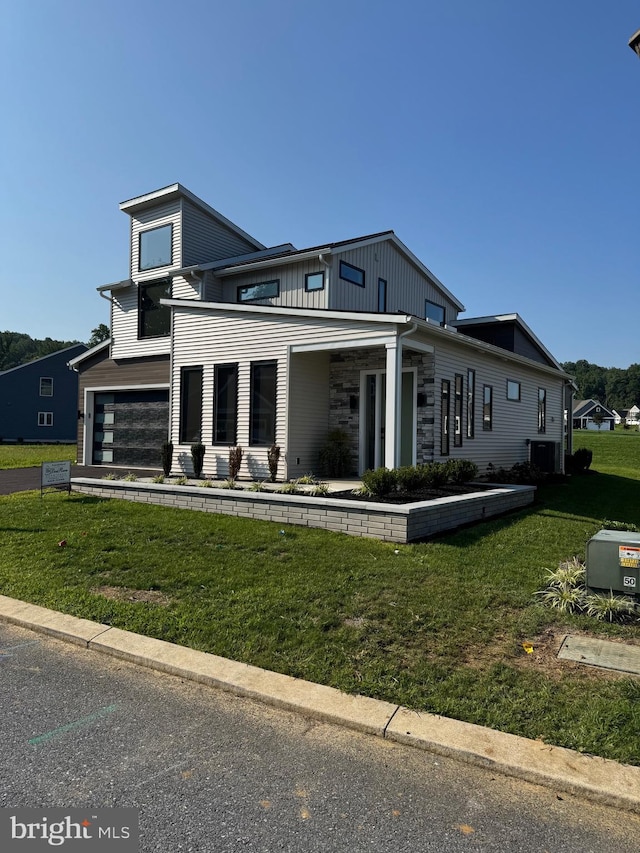 view of front of house with a front yard, stone siding, and central AC unit