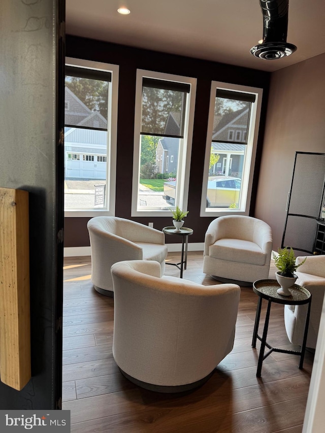 living room featuring baseboards, wood finished floors, and recessed lighting