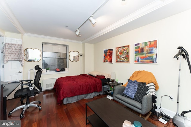 bedroom with crown molding, rail lighting, and dark wood-type flooring