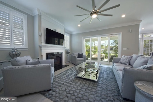 living room with ceiling fan, crown molding, and a wealth of natural light