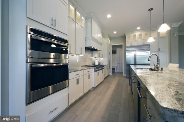 kitchen with tasteful backsplash, light hardwood / wood-style floors, appliances with stainless steel finishes, and white cabinetry