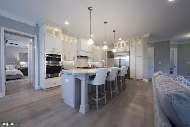 kitchen with pendant lighting, light hardwood / wood-style floors, stainless steel appliances, ceiling fan, and white cabinets