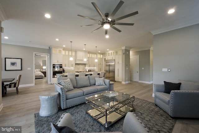 living room with crown molding, ceiling fan, and light hardwood / wood-style flooring