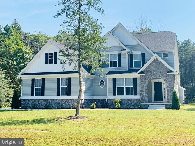 view of front of house with central AC unit and a front yard