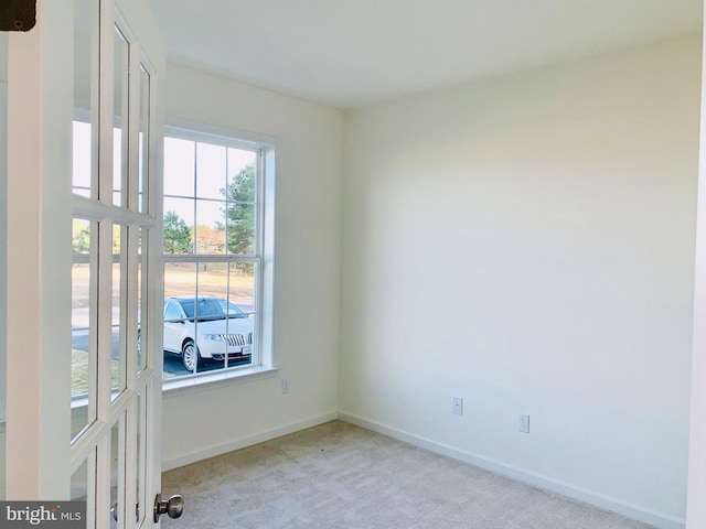 spare room featuring light carpet