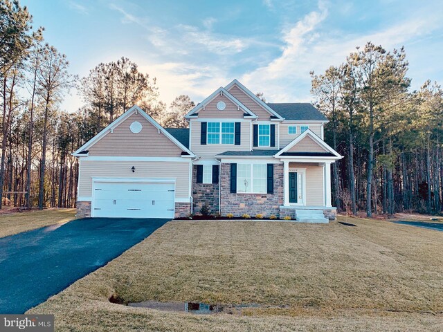 craftsman-style home featuring a front lawn, a porch, and a garage