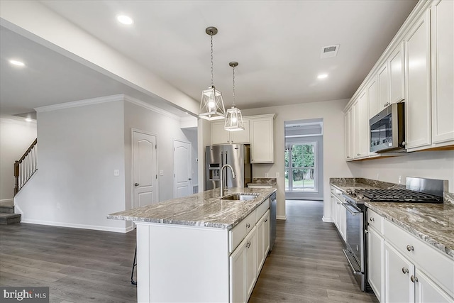 kitchen featuring stainless steel appliances, a kitchen island with sink, dark hardwood / wood-style floors, and white cabinetry