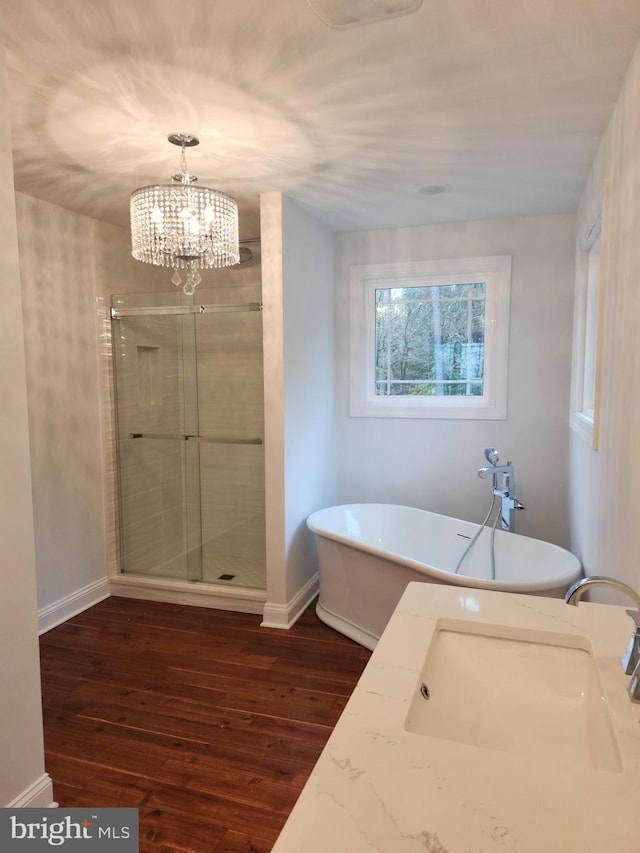 bathroom with a chandelier, independent shower and bath, wood-type flooring, and sink