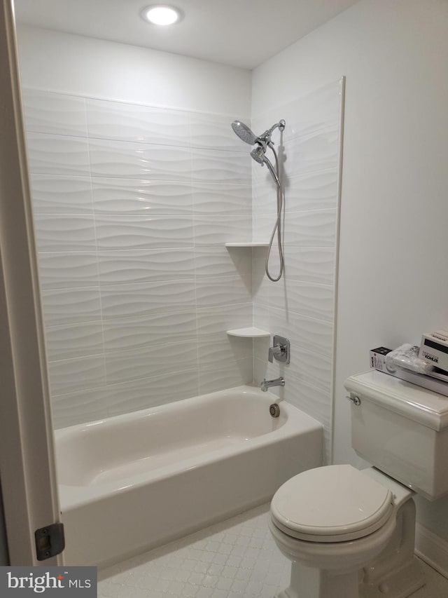 bathroom with tiled shower / bath combo, tile floors, and toilet