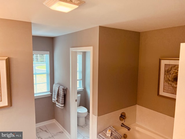 bathroom featuring tile floors, toilet, and a washtub