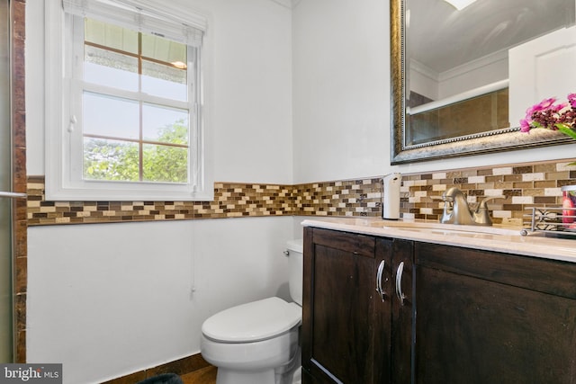 bathroom featuring ornamental molding, toilet, large vanity, and tasteful backsplash