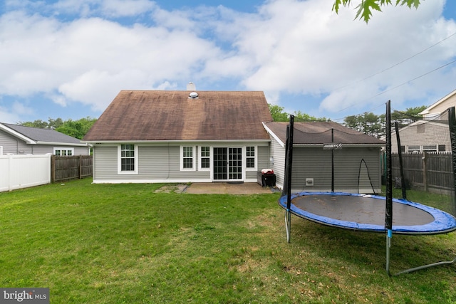 back of house with a yard, a trampoline, and a patio area