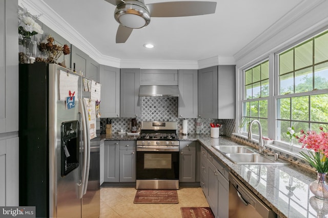 kitchen featuring backsplash, appliances with stainless steel finishes, light tile floors, ceiling fan, and sink