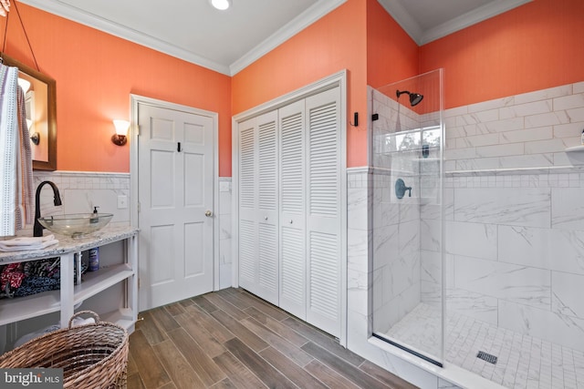 bathroom featuring vanity, tasteful backsplash, ornamental molding, hardwood / wood-style floors, and an enclosed shower