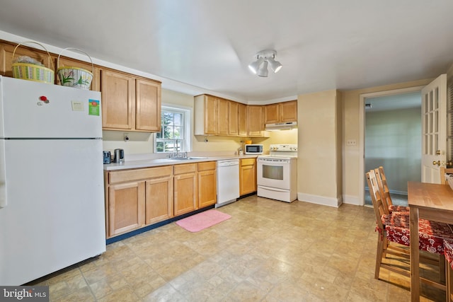 kitchen with light tile flooring, sink, and white appliances