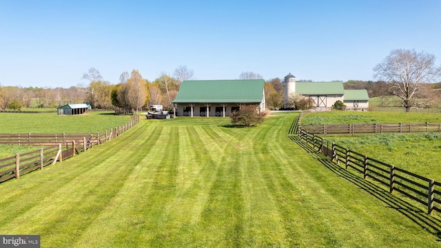 view of yard with a rural view and an outdoor structure