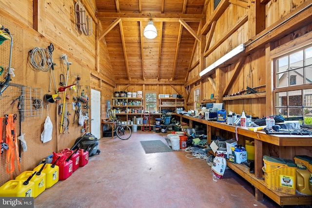 garage featuring wooden walls, a workshop area, and wood ceiling