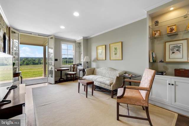 sitting room with light hardwood / wood-style flooring and crown molding