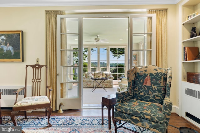 living area featuring ceiling fan, radiator, ornamental molding, and hardwood / wood-style flooring