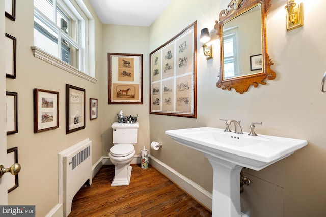 bathroom with toilet, wood-type flooring, and radiator