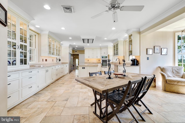 dining space with ceiling fan, sink, and light tile floors