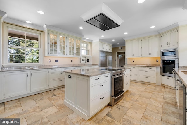 kitchen with built in appliances, light tile floors, a center island, light stone countertops, and white cabinets