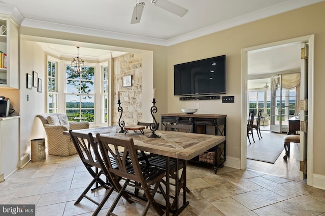 dining space featuring crown molding, light tile floors, and ceiling fan with notable chandelier