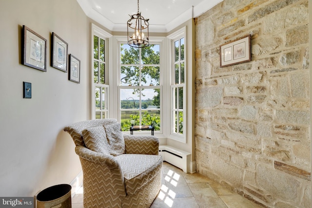 sitting room with crown molding, an inviting chandelier, light tile floors, and baseboard heating