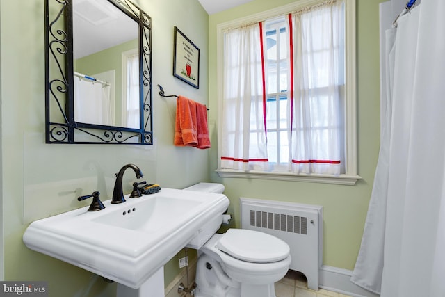 bathroom with sink, tile floors, radiator heating unit, and toilet