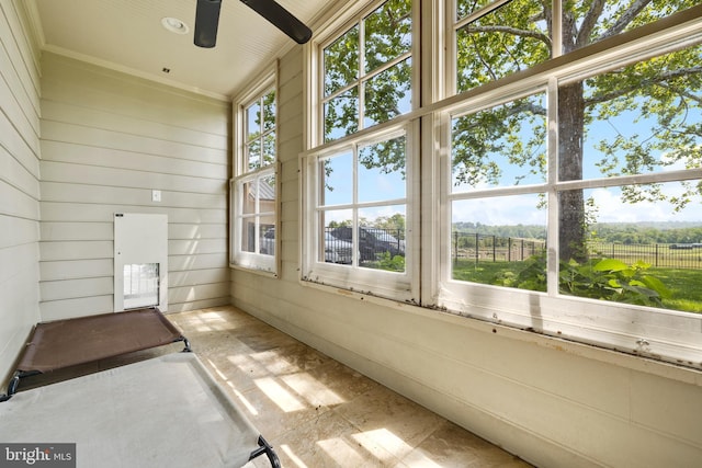 unfurnished sunroom with ceiling fan