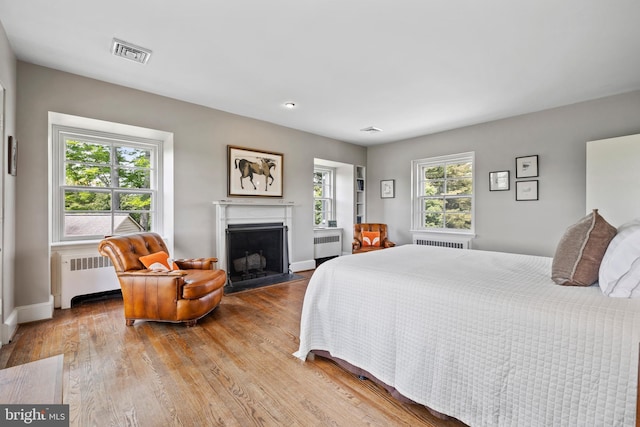 bedroom featuring light hardwood / wood-style flooring and radiator heating unit