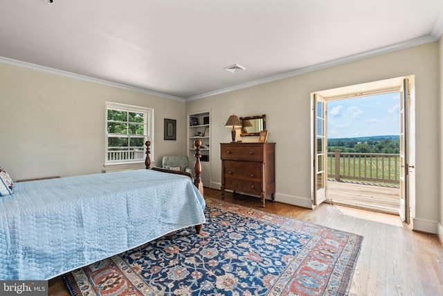 bedroom featuring access to exterior, ornamental molding, and light wood-type flooring