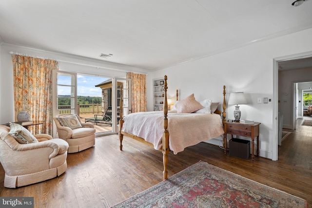 bedroom featuring access to exterior, dark wood-type flooring, and multiple windows