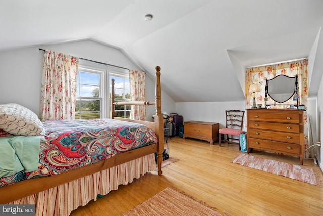 bedroom with light hardwood / wood-style floors and vaulted ceiling