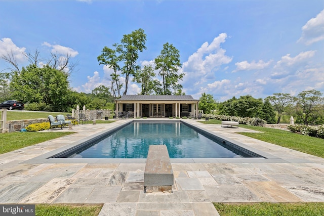 view of swimming pool with a patio and a yard