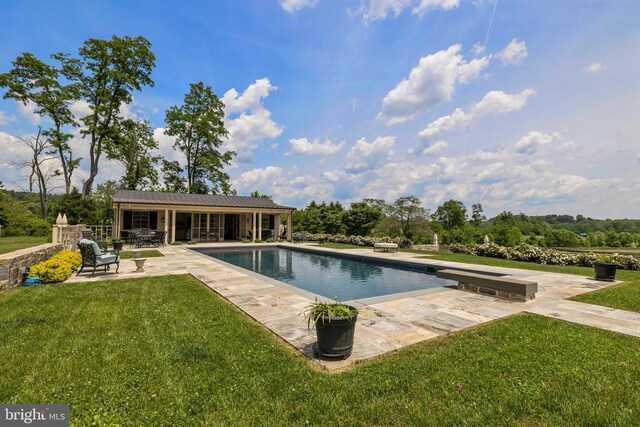 view of pool with a patio area and a lawn